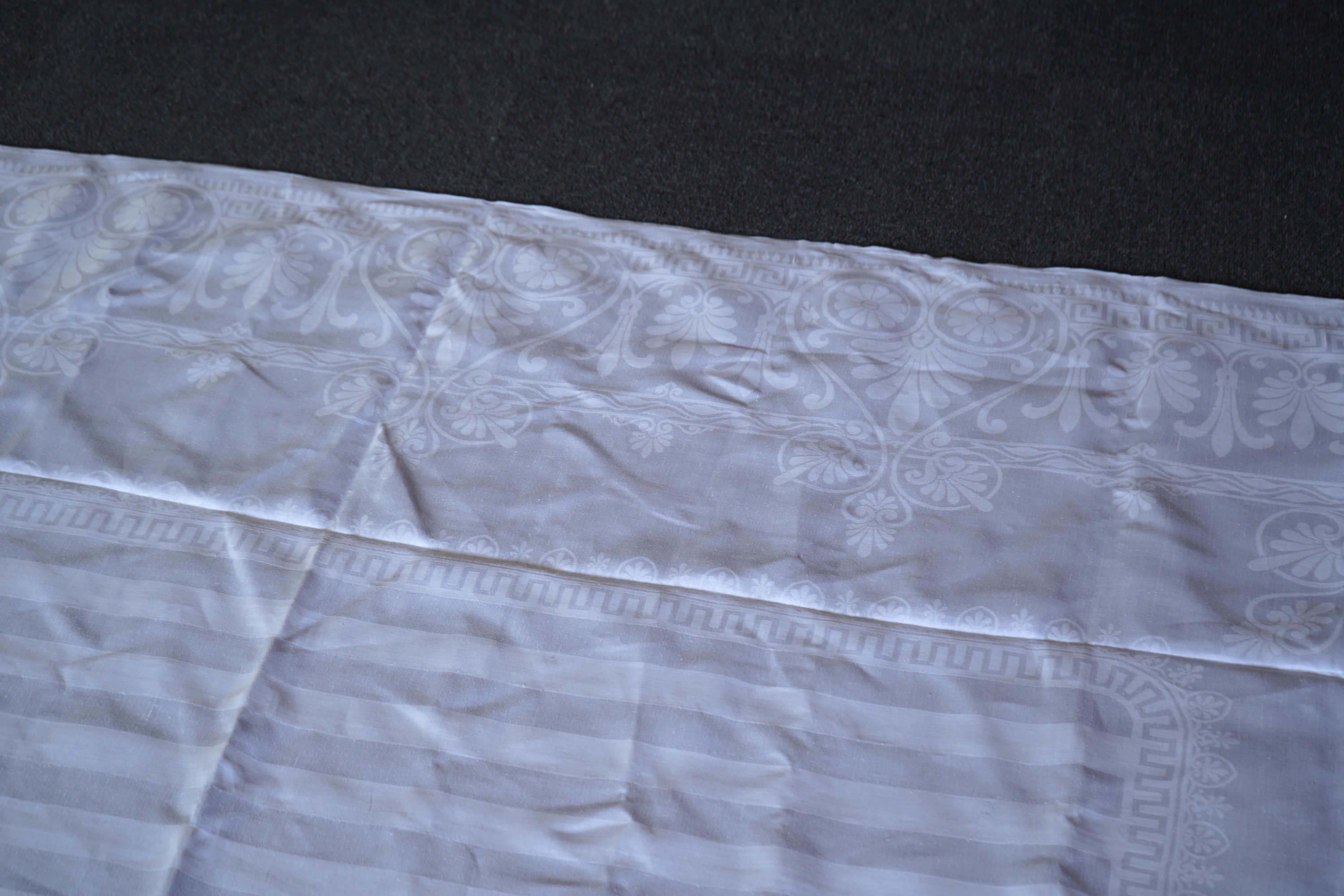 A late 19th century large white Irish damask table cloth, woven with an all over Christopher Dresser ‘inspired’ design. The overall design incorporating many of his known stylistic design motifs. Each corner has a shamro